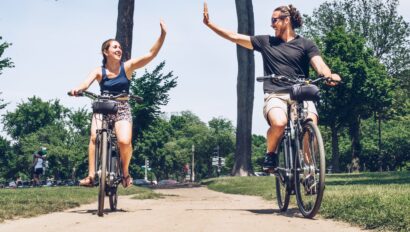 A couple high fives in mid-air as they ride e-bikes in Washington, D.C.