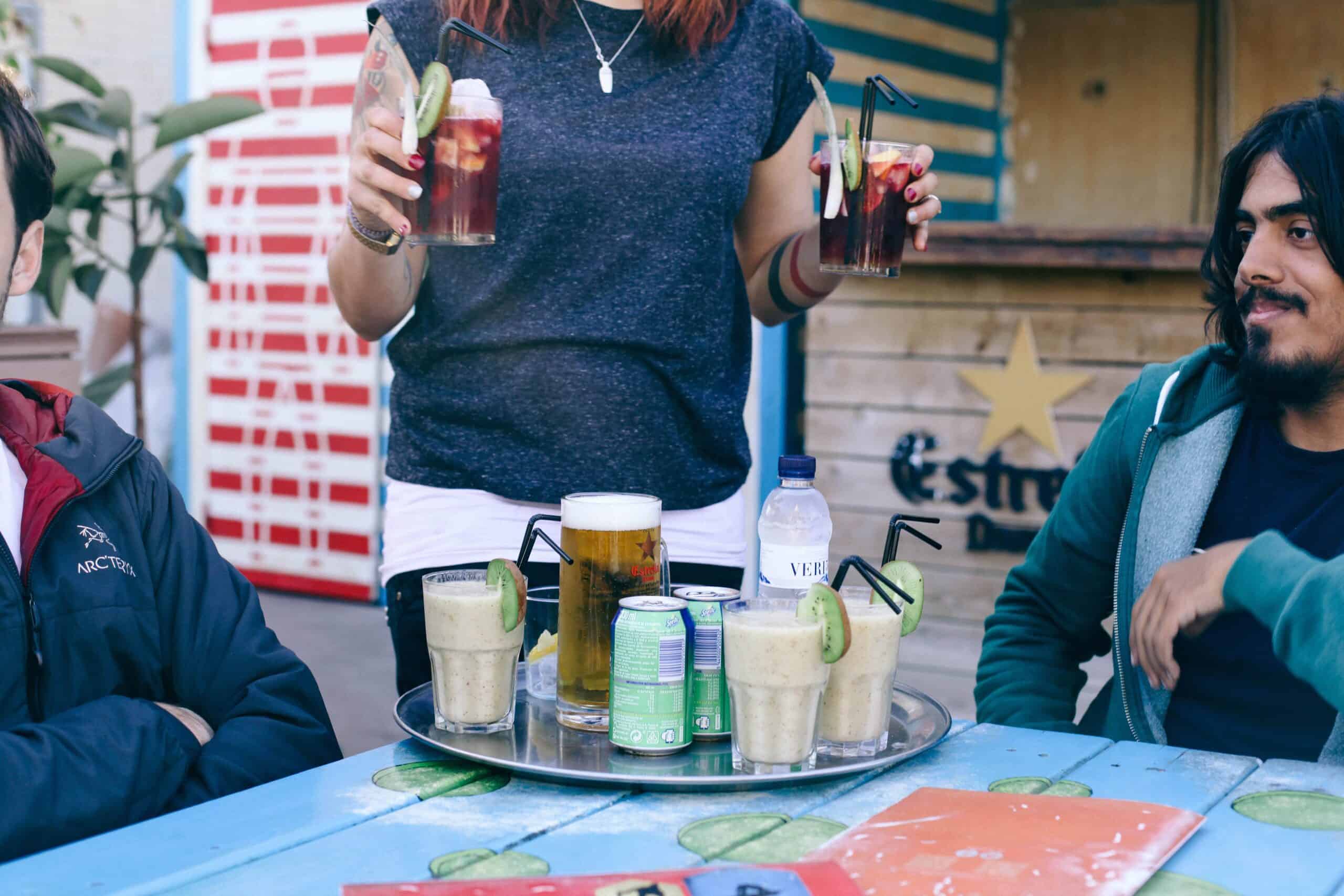 A woman serves drinks at a beach café in Barcelona, Spain