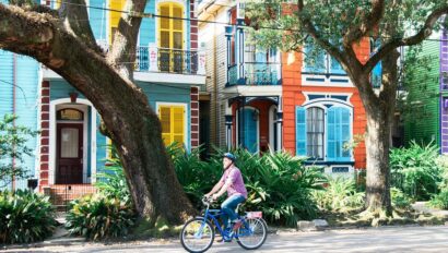 A man rides his bike in front of colorful houses in the French Quarter in New Orleans, Louisiana