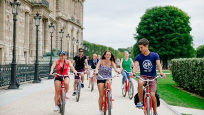 A group on bikes rides around the Louvre in Paris, France