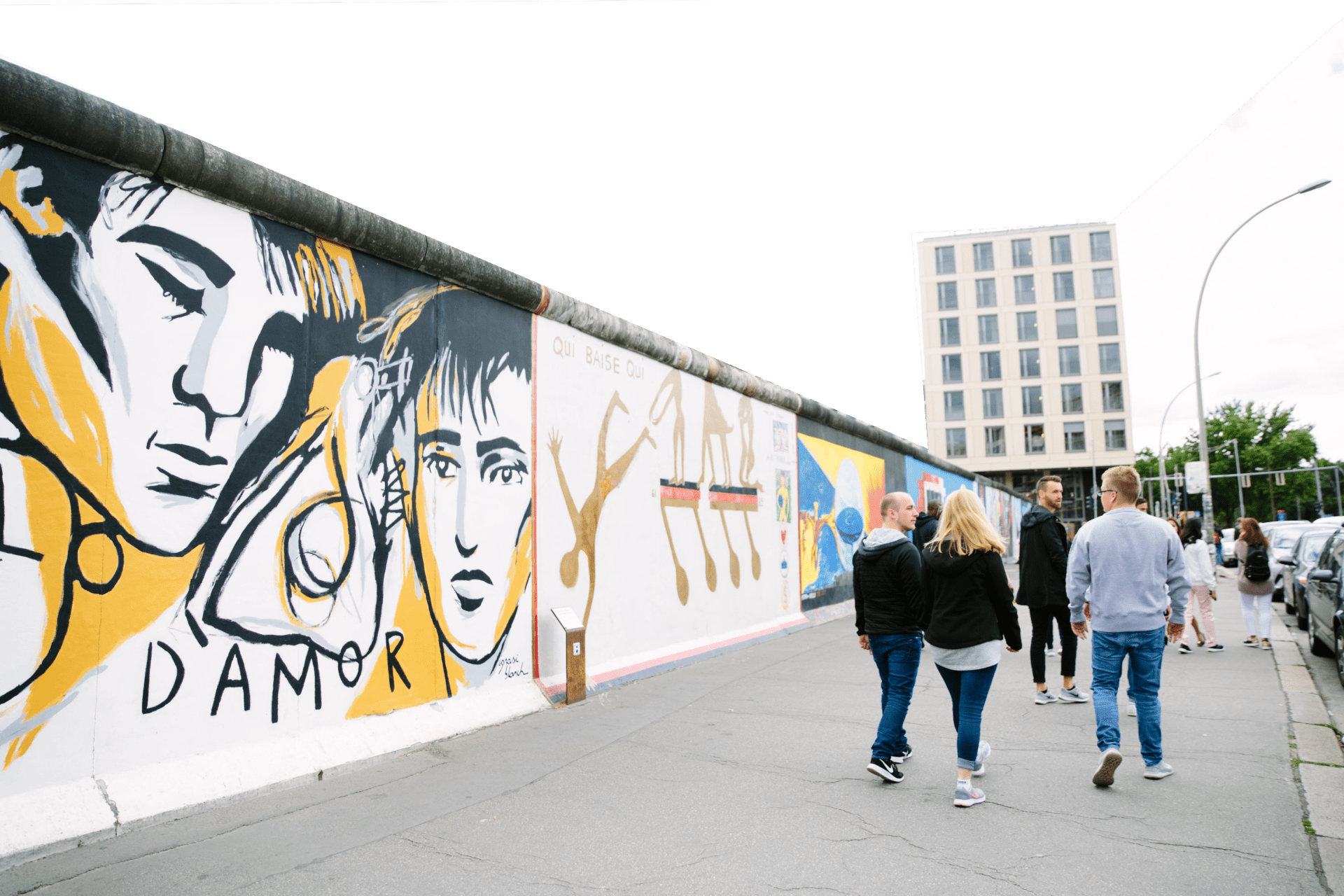 People walk alongside the Berlin Wall