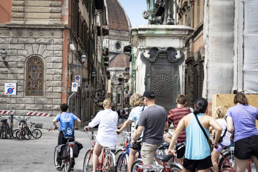 A group of cyclists rides through the streets of Florence, Italy