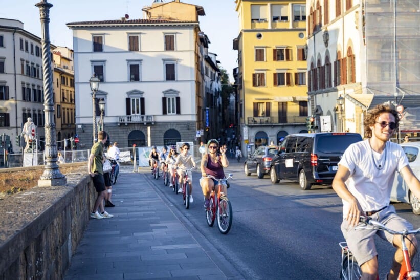 A group of cyclists rides through Florence, Italy