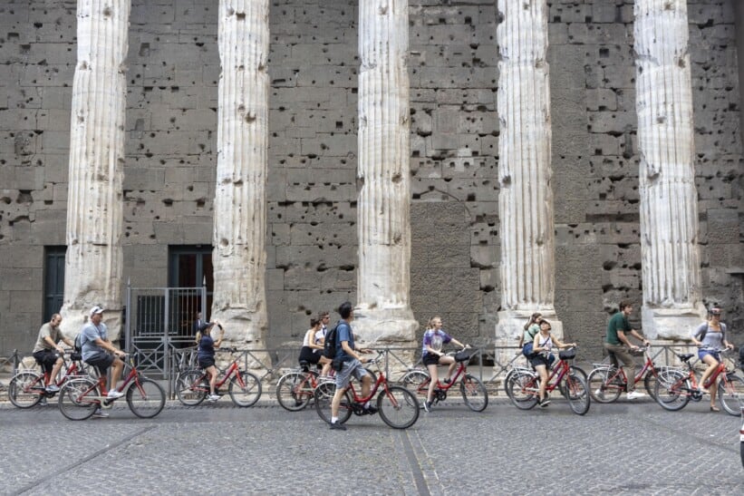 A group of cyclists pauses to admire the magnitude of the Pantheon in Rome, Italy