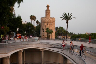 a group bikes over a bridge in seville