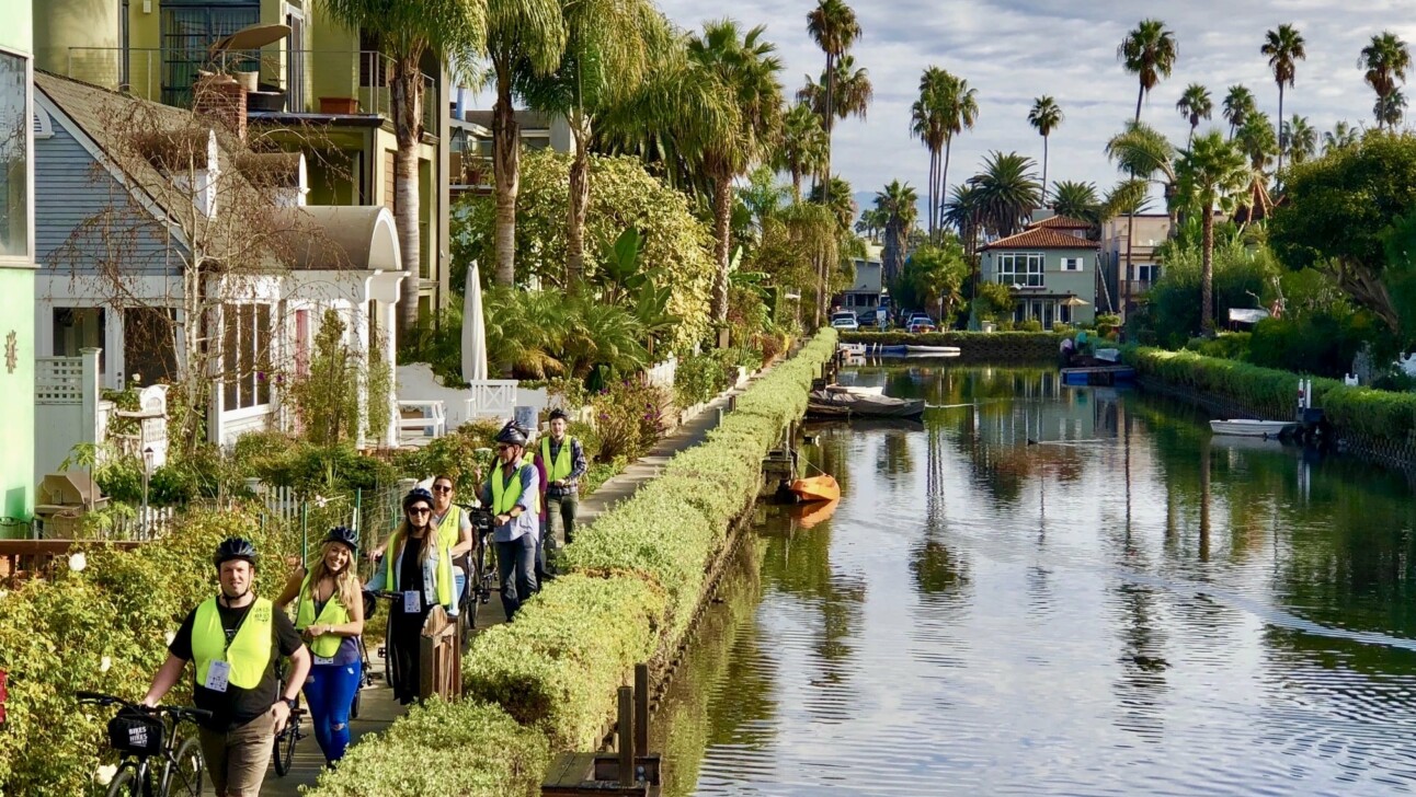 Cyclists ride along the Venice Canal in Los Angeles, California