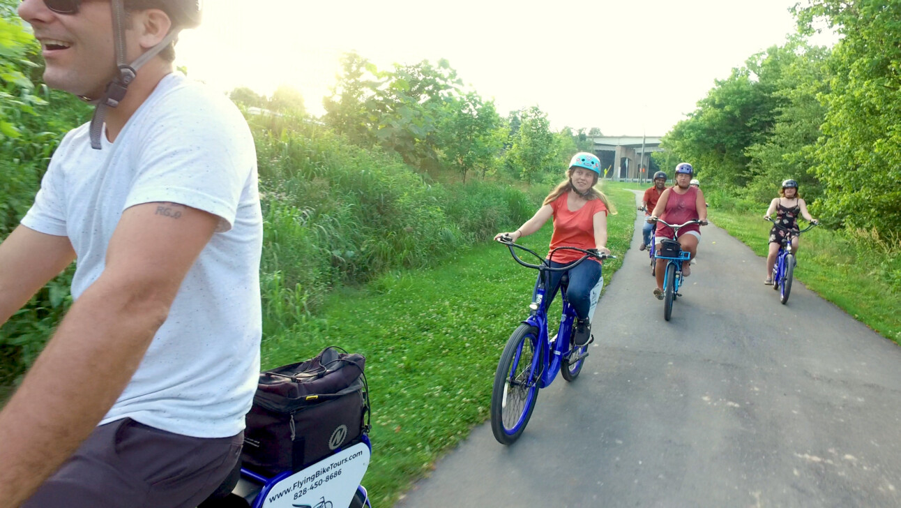 A group of cyclists ride along Reid Creek Greenway in Asheville, North Carolina