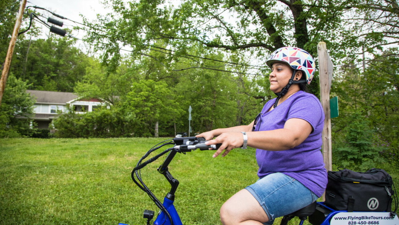 A women enjoys riding her bicycle through nature in Asheville, North Carolina