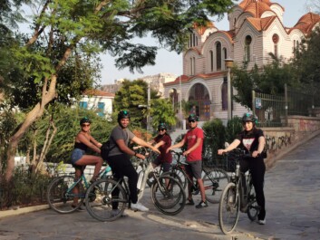 A group of cyclists pose for a photo in front of the Marina Church in Athens, Greece