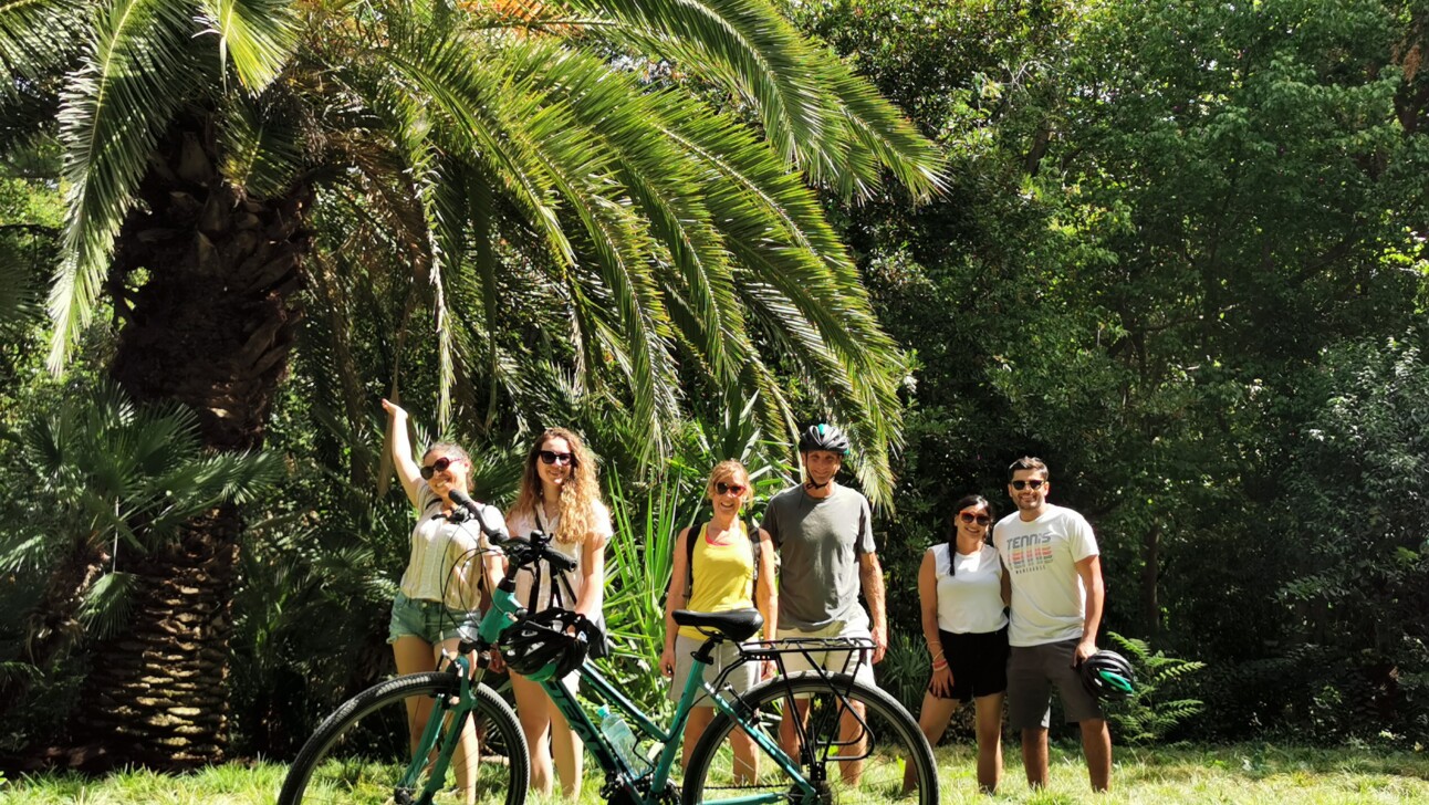 A group of cyclists pose for a photo in the National Gardens in Athens, Greece