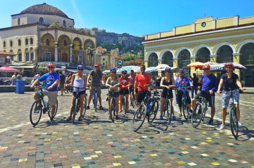 A group of cyclists pose for a photo while in the Monastiraki neighborhood in Athens, Greece