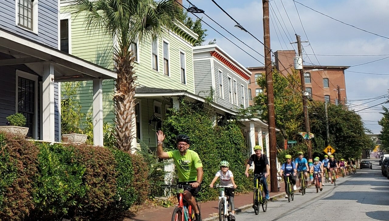 A group of cyclists ride through Cabbagetown, Atlanta, Georgia