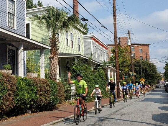 A group of cyclists ride through Cabbagetown, Atlanta, Georgia