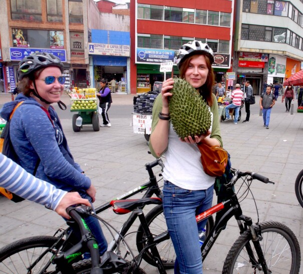 A women holds up a durian fruit outside the market in Bogota, Colombia