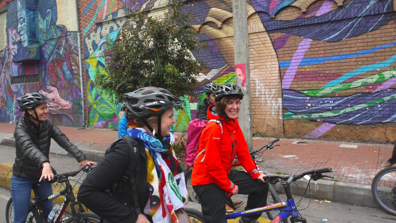 A group of cyclists stop to admire the street art in Bogota, Colombia