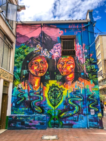 A large street art mural of women and a heart in Bogota, Colombia