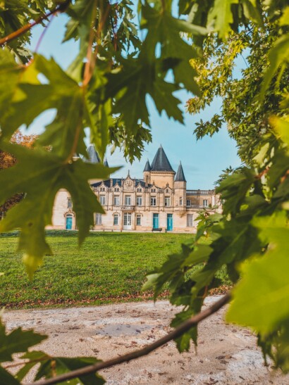 A chateau in Bordeaux, France as seen through the trees