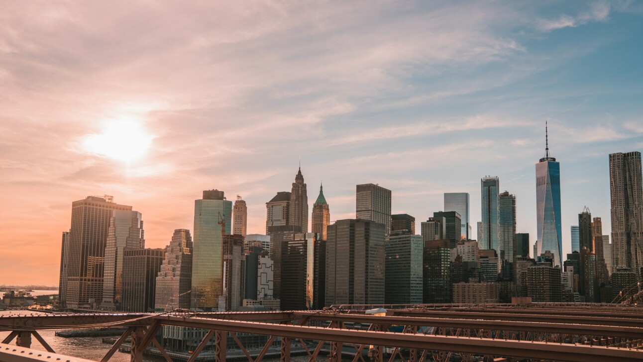 A panoramic view of Manhattan from the Brooklyn Bridge in New York City as the sun is setting
