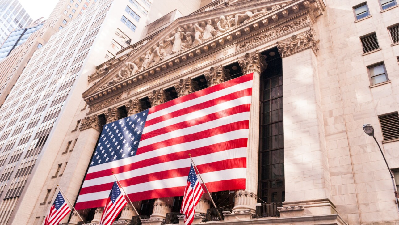 An American flag across the front of the New York Stock Exchange on Wall Street, New York City