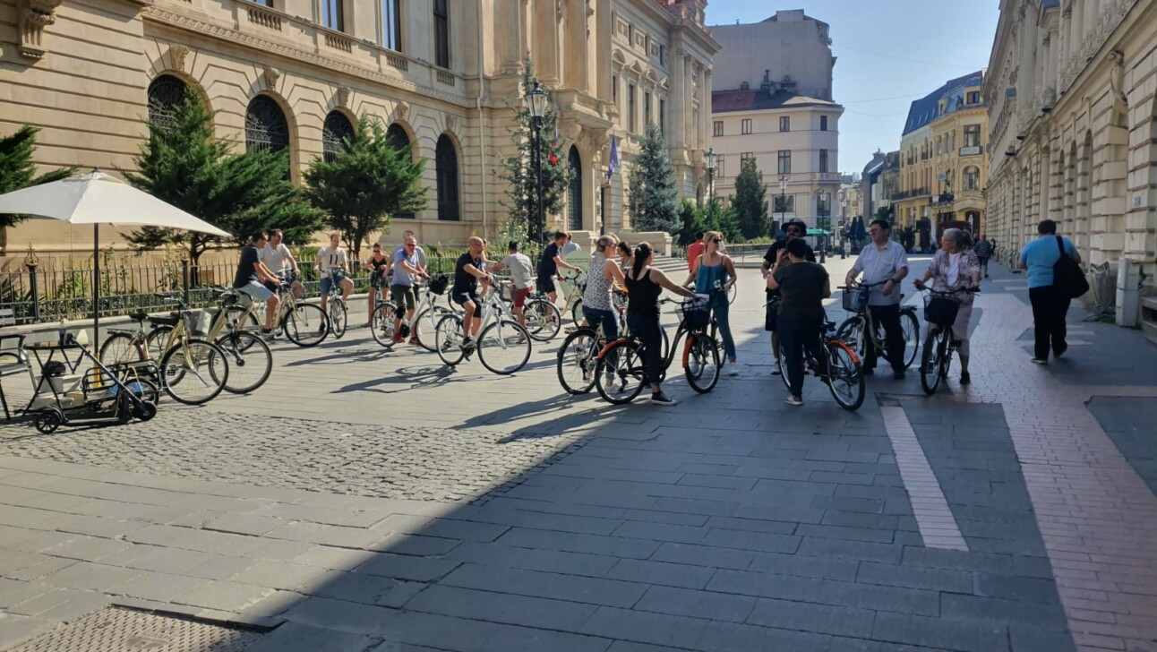 A group of cyclists pause along Lipscani Street in Bucharest, Romania