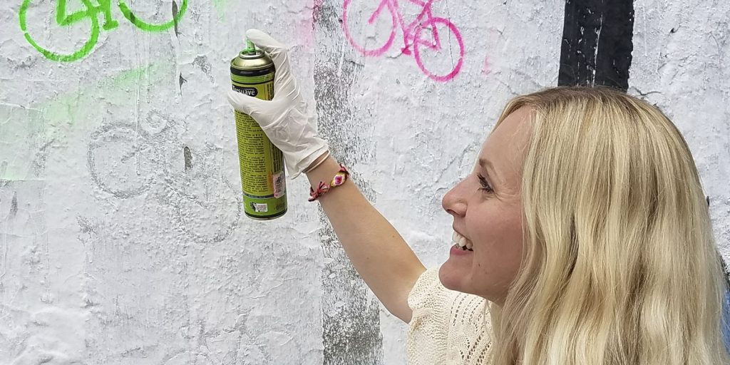 A woman spray painting a wall