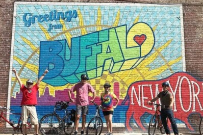 A group of cyclists in front of the Buffalo, New York street mural