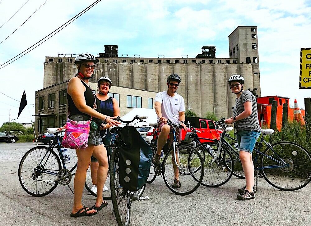 A group of cyclists pose for a photo with their bikes in Silo City Buffalo, New York