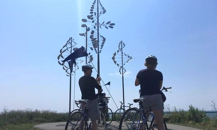 Two people take photos of the wind chimes at Wilkeson Pointe Park
