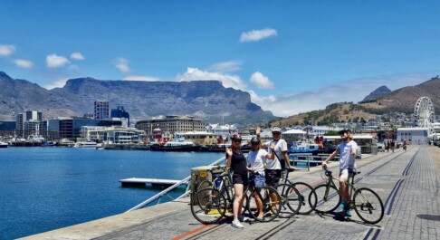 a group of cyclists along the water in Cape Town, South Africa