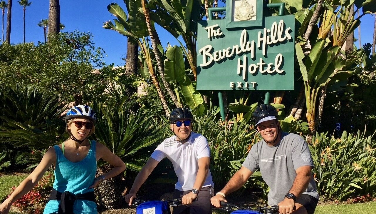 Cyclists stop outside the Beverly Hills Hotel in Los Angeles, California