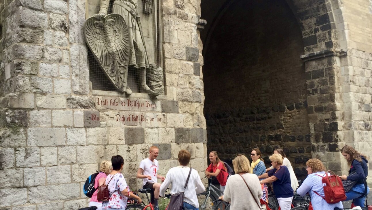 A group of cyclists in front of Stadtmauer in Cologne, Germany