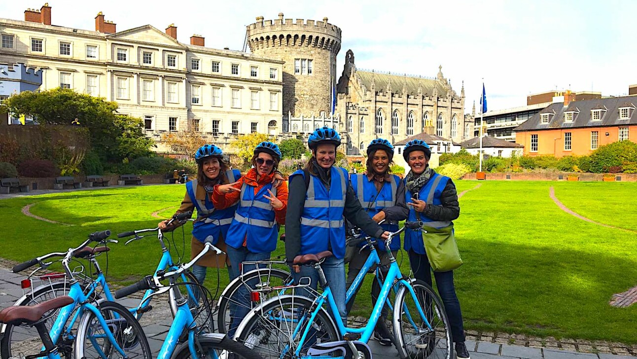 Cyclists pose in front of the Dublin castle