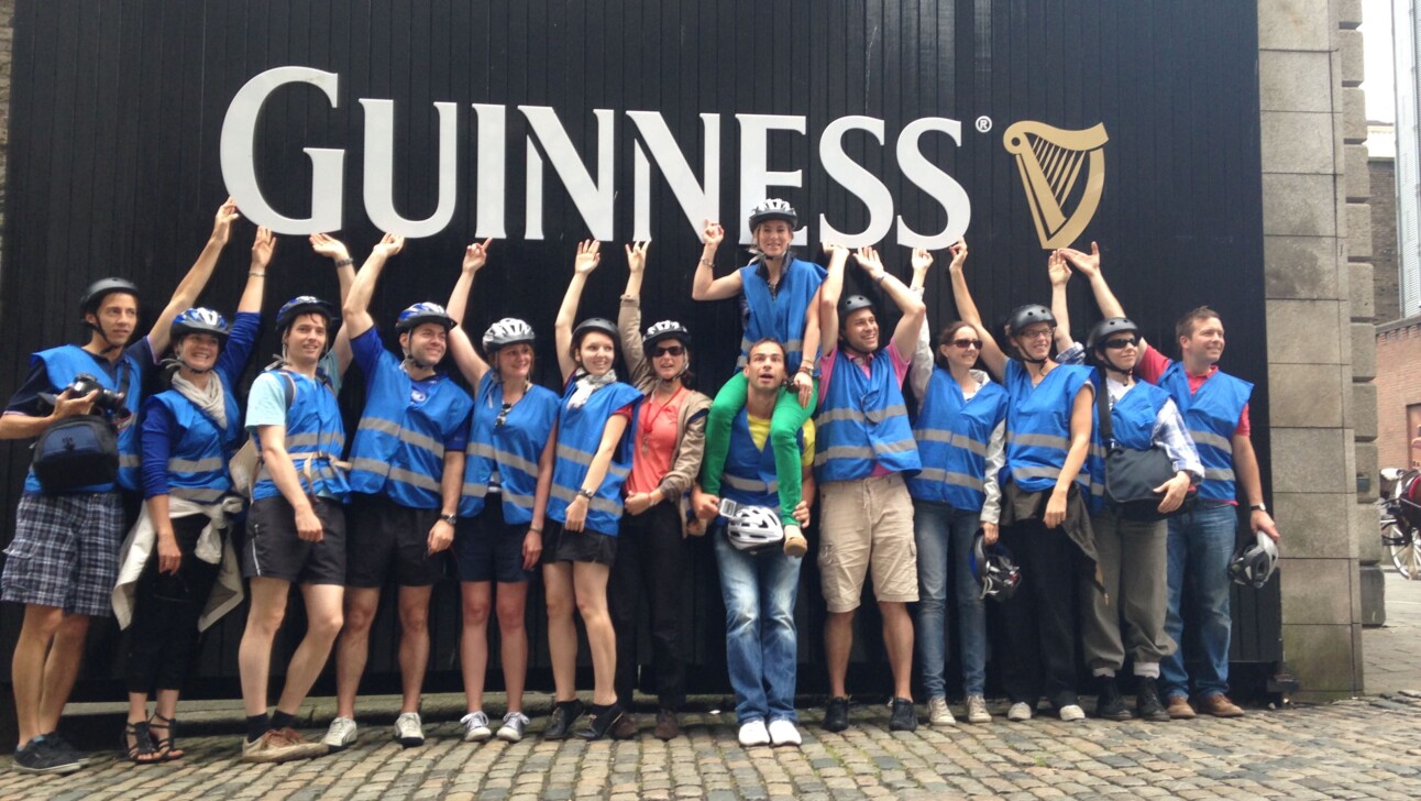 A group of people pose in front of the Guinness sign at the factory in Dublin, Ireland