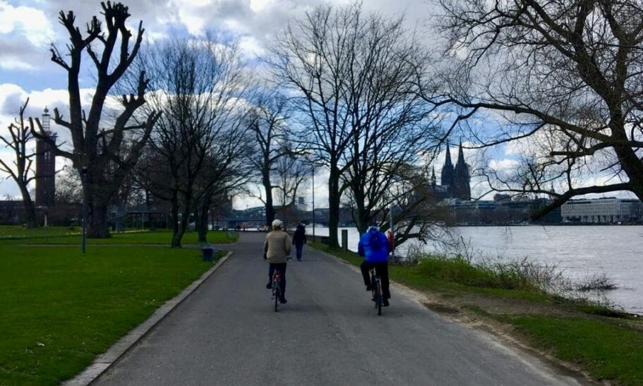 Riding along a bike path by the water in Cologne, Germany
