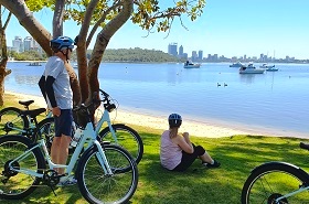 A group of cyclists take a break at the shore of Matilda Bay in Perth, Australia
