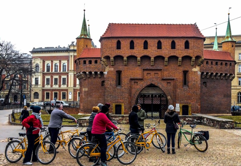 A group of cyclists in at the entrance of Planty Park in Krakow, Poland