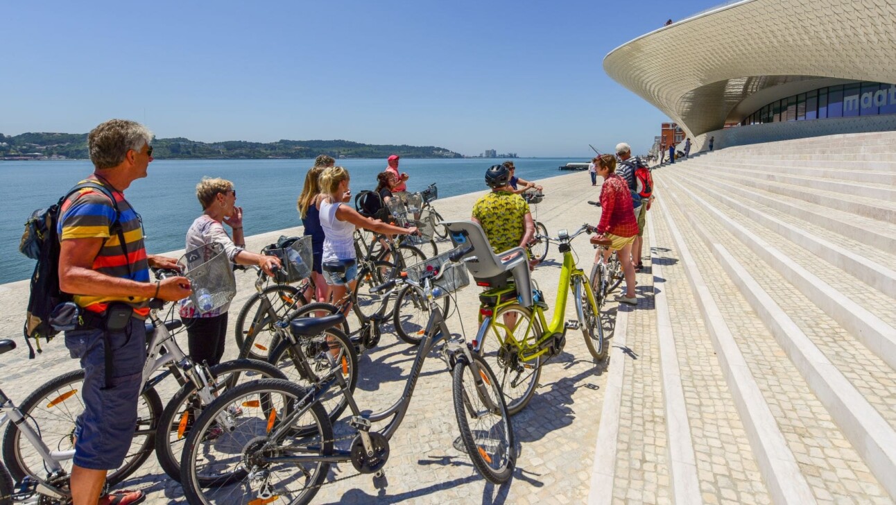 Cyclists stop to see and hear about the new MAAT museum in Lisbon, Portugal