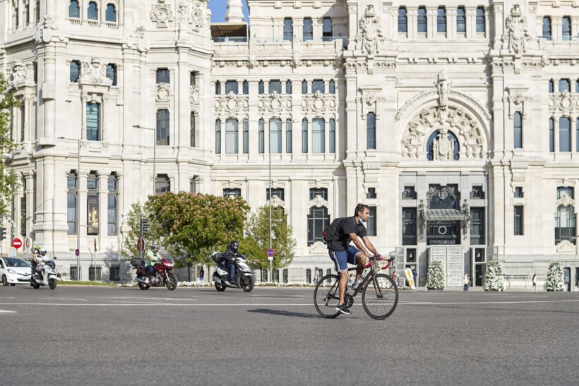 A man cycles through a main square in Madrid, Spain