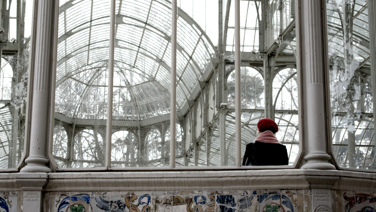 A woman stares at the glass ceiling in the Crystal Palace in Madrid, Spain