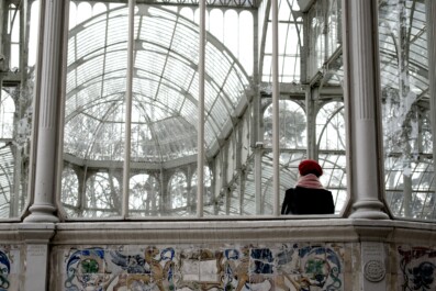 A woman stares at the glass ceiling in the Crystal Palace in Madrid, Spain