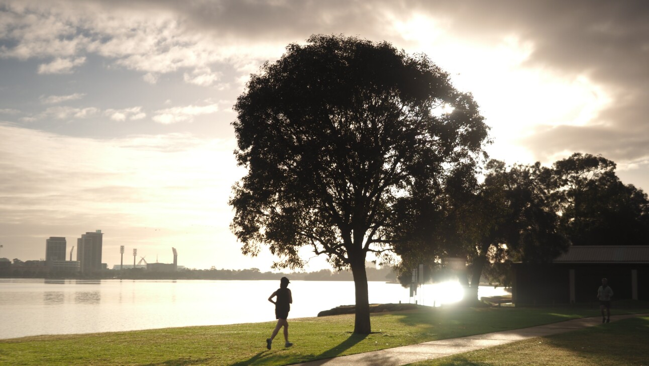 A runner at dusk near the Swan River in Perth, Australia