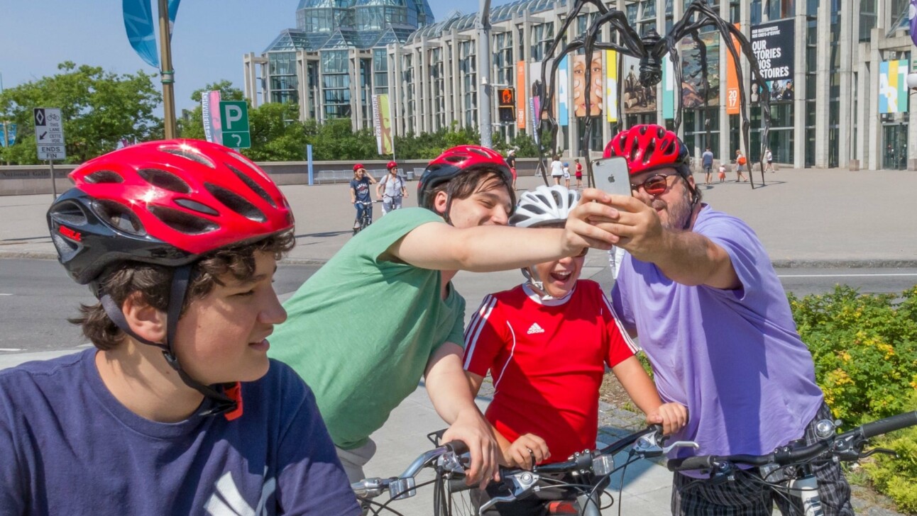 Cyclists take a photo in front of the National Gallery of Canada in Ottawa