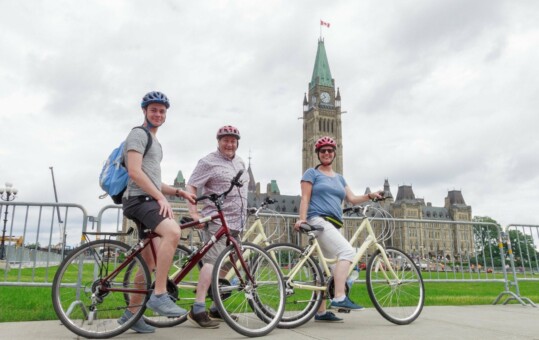 Cyclists in front of the Parliament building in Ottawa, Canada