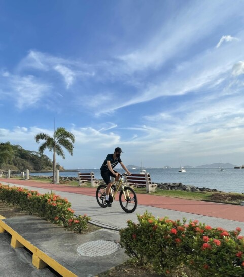 A man cycling by the water in Panama City