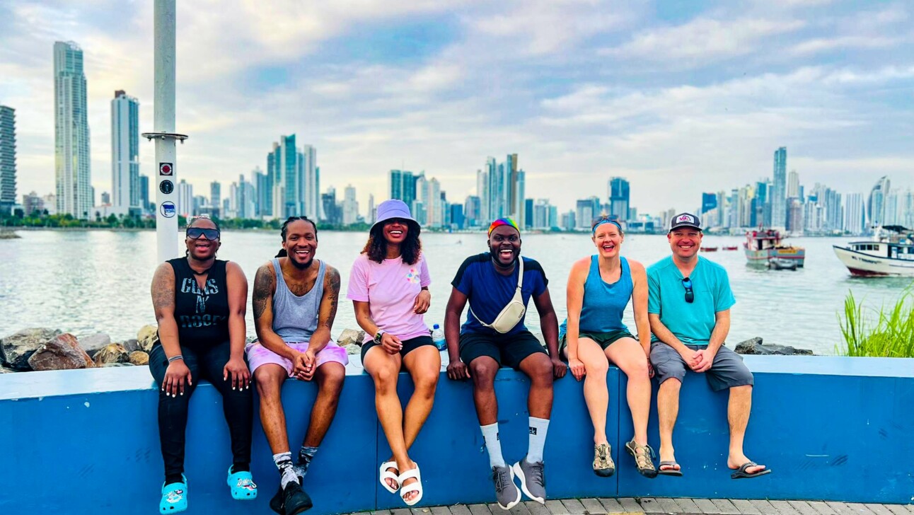 A group sitting on a wall at Cinta Costera in Panama City