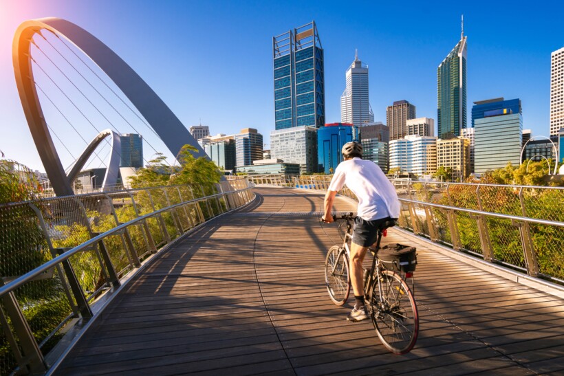 A man bikes across a bridge in Perth, Australia