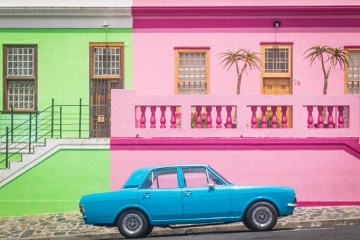 A blue car parked in front of a pink house in Bo Kaap, South Africa