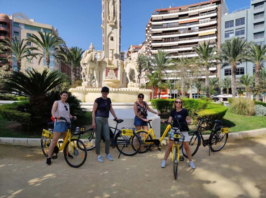 People posing with their bikes in Canalejas Square in Alicante, Spain