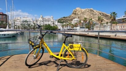 A yellow bike parked along the water in Alicante