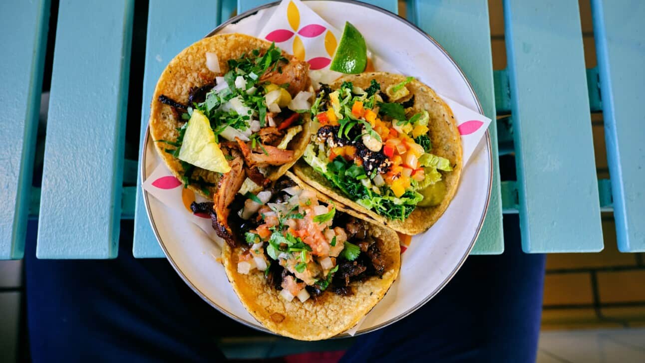 Three colorful tacos with lots of toppings